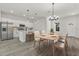 Bright, open kitchen and dining area featuring modern white cabinetry and contemporary light fixtures at 4513 Sw 170Th Rd, Ocala, FL 34473