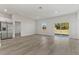 Spacious living room with wood floors, sliding glass doors, and a stainless steel refrigerator in the kitchen at 4513 Sw 170Th Rd, Ocala, FL 34473