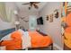 Bright bedroom with orange bedding and ceiling fan at 6689 Bell Glade Pl, Sanford, FL 32771