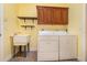 Efficient laundry room with modern washer, dryer, utility sink, and ample storage cabinets at 6689 Bell Glade Pl, Sanford, FL 32771