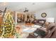 Bright and airy living room with leather furniture and a Christmas tree at 6689 Bell Glade Pl, Sanford, FL 32771