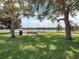 A green bench surrounded by lush lawn and trees offers a relaxing spot to enjoy the scenic lake view at 7321 Brightland St, Windermere, FL 34786
