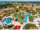 Aerial view of resort-style pool area with multiple pools, a waterslide, and lounge chairs at 100 Palermo St, Davenport, FL 33897