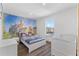 Bedroom with stylish castle wall art, crib, and bright natural light at 100 Palermo St, Davenport, FL 33897