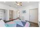 Bedroom featuring sleek closet, bathroom access, and modern ceiling fan at 100 Palermo St, Davenport, FL 33897