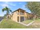 View of the condo featuring a balcony, screened-in porch, and a well-maintained lawn with palm tree at 100 Palermo St, Davenport, FL 33897