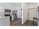 Bright kitchen featuring white cabinetry, stainless steel appliances, and wood-look flooring at 100 Palermo St, Davenport, FL 33897