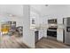 Modern kitchen open to living area with stainless steel appliances and white cabinets at 100 Palermo St, Davenport, FL 33897