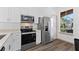 Clean kitchen featuring white cabinets, stainless steel appliances, and wood-look floors at 100 Palermo St, Davenport, FL 33897
