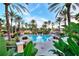 An inviting community pool area with lounge chairs, umbrellas, and vibrant tropical foliage at 100 Palermo St, Davenport, FL 33897