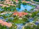 An aerial view showcases colorful townhomes, a blue pond, and a pool with the clubhouse and playground nearby at 167 Castaway Beach Way, Kissimmee, FL 34746