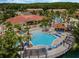 An aerial view of the large pool area with a splash pad, playground, lounge chairs, and the clubhouse nearby at 167 Castaway Beach Way, Kissimmee, FL 34746