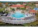 An aerial view shows a beautiful pool, bridge, and clubhouse with tables and chairs surrounding the pool area at 167 Castaway Beach Way, Kissimmee, FL 34746