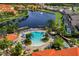 A beautiful pool is surrounded by lounge chairs and palm trees near a lake with a fountain feature at 167 Castaway Beach Way, Kissimmee, FL 34746