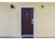 A brown front door with a door knocker in a light yellow building at 411 Lucaya Loop # 411, Davenport, FL 33897