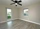 Bedroom features wood floors, ceiling fan, and two windows for plenty of light at 1048 Wakefield Cir, Deltona, FL 32725