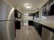 Updated kitchen with stainless steel appliances and modern gray cabinets at 1048 Wakefield Cir, Deltona, FL 32725