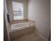 The bathroom features a tiled garden tub and a large window with blinds at 8979 Azalea Sands Ln, Davenport, FL 33896