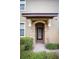 Inviting home entrance with a stone-framed doorway, tiled roof, and manicured bushes at 8979 Azalea Sands Ln, Davenport, FL 33896