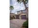 Charming two-story home featuring a stone facade, brown garage doors, and well-manicured landscaping at 8979 Azalea Sands Ln, Davenport, FL 33896