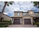 Inviting two-story home showcasing a stone facade, brown garage doors, and lush landscaping at 8979 Azalea Sands Ln, Davenport, FL 33896