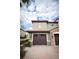 Two-story home with brown garage doors and lush landscaping, under a cloudy sky at 8979 Azalea Sands Ln, Davenport, FL 33896