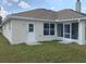 Back of house with a screened porch and white door at 9875 Sw 55Th Ct, Ocala, FL 34476