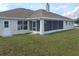 Home's backyard features a screened patio and grassy area at 9875 Sw 55Th Ct, Ocala, FL 34476