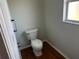 Small bathroom with toilet and hardwood floor at 9875 Sw 55Th Ct, Ocala, FL 34476