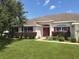 Single-story home with a red door and well-manicured lawn at 9875 Sw 55Th Ct, Ocala, FL 34476