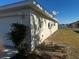 View of the house's side, highlighting the garage and satellite dishes at 9875 Sw 55Th Ct, Ocala, FL 34476