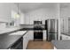 Well-equipped kitchen featuring stainless steel appliances, white cabinets, and dark countertops at 3623 Worth Cir, The Villages, FL 32162