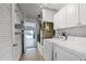 Functional laundry room with washer, dryer, and storage shelves leading to the garage at 3623 Worth Cir, The Villages, FL 32162