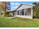 Back of house featuring an enclosed lanai and landscaped backyard at 3623 Worth Cir, The Villages, FL 32162