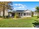 Back of house featuring an enclosed lanai and landscaped backyard at 3623 Worth Cir, The Villages, FL 32162
