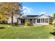 Back of house featuring an enclosed lanai and landscaped backyard at 3623 Worth Cir, The Villages, FL 32162