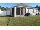 Relaxing backyard featuring a covered lanai, verdant lawn, and charming picnic table at 10198 Oak Crest Rd, Orlando, FL 32829