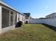 Spacious backyard with lawn, screened patio, and white vinyl fencing for privacy at 10198 Oak Crest Rd, Orlando, FL 32829