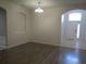 Open living room with arched entryways and wood-look flooring, bathed in natural light at 10198 Oak Crest Rd, Orlando, FL 32829