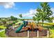Community playground with slide, climbing area, and swing set overlooking the pond at 10198 Oak Crest Rd, Orlando, FL 32829