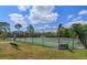 Well-maintained community tennis courts with black chain-link fencing, surrounded by lush trees at 10198 Oak Crest Rd, Orlando, FL 32829