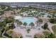 Aerial view showcases the community pool, clubhouse, palm trees and surrounding neighborhood at 1593 Mulligan Blvd, Davenport, FL 33896