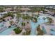 Aerial view shows pool areas, water slide, lazy river, palm trees, and seating at the community center at 1593 Mulligan Blvd, Davenport, FL 33896