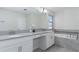 Elegant bathroom featuring double sinks, quartz countertops, and a soaking tub at 1593 Mulligan Blvd, Davenport, FL 33896