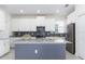 Bright kitchen featuring a large island, stainless steel appliances, and modern finishes at 1593 Mulligan Blvd, Davenport, FL 33896