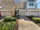 Charming townhome featuring a brick driveway, manicured shrubs and a single-car garage at 1106 Presidential Ln, Apopka, FL 32703
