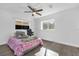 Bright bedroom with white walls, wood-look flooring, a ceiling fan, and natural light from two windows at 4535 Arch St, Orlando, FL 32808