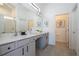 Bathroom features double vanity with gray cabinetry, granite countertop, a large mirror and tile flooring at 6240 Sand Skipper Rd, Orlando, FL 32821