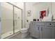 Well-lit bathroom with a walk-in shower, gray vanity, and modern fixtures at 6240 Sand Skipper Rd, Orlando, FL 32821