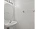 A pedestal sink with an oval mirror and globe lighting in a minimalist half bath at 13228 Daniels Landing Cir, Winter Garden, FL 34787